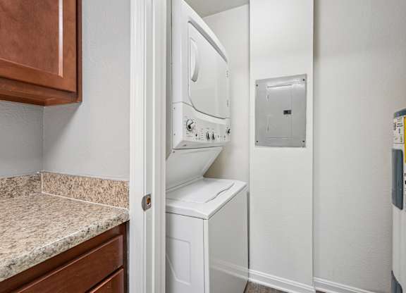 A white dryer is in a small laundry room.
